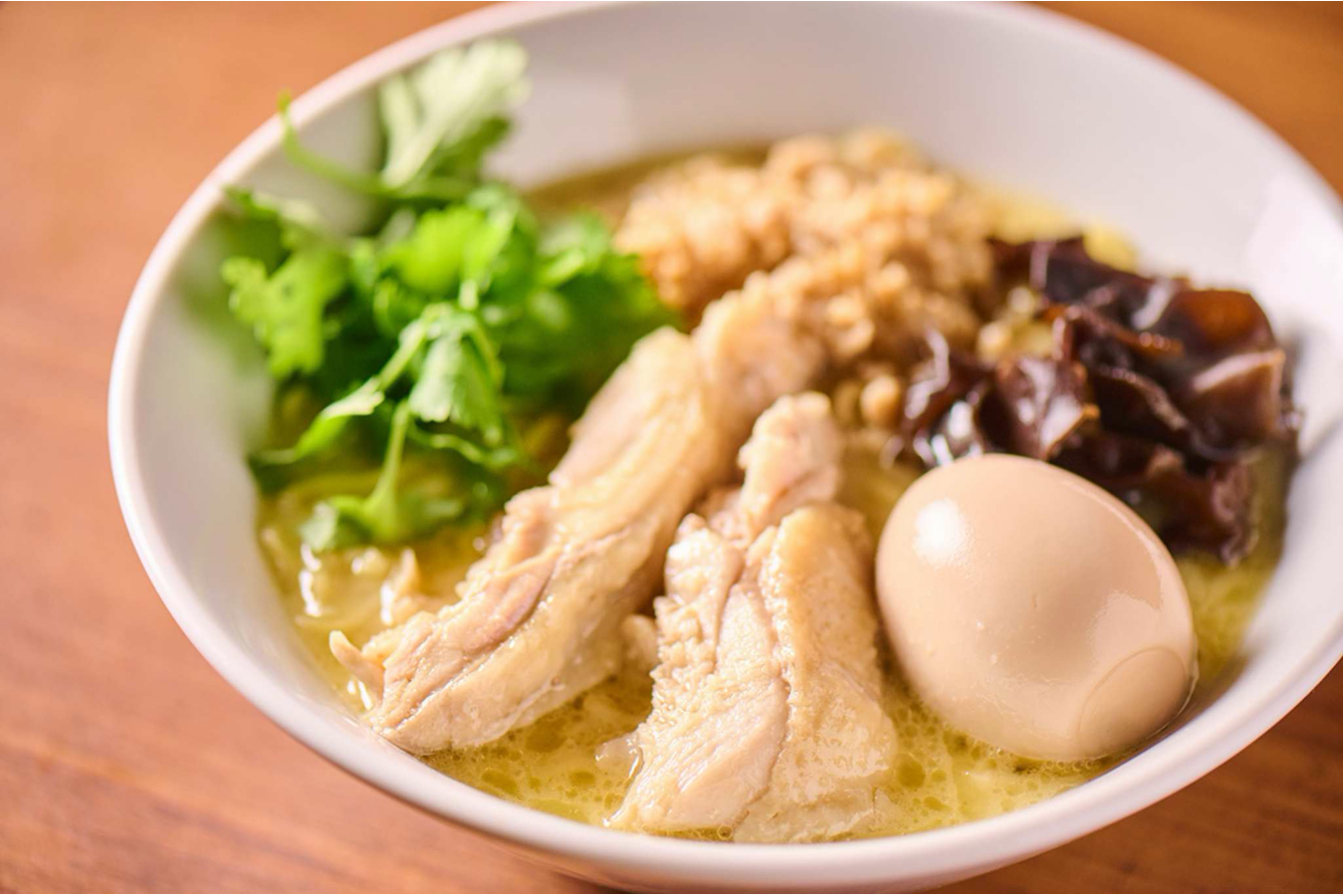 ▲「全部のせ鶏白湯ラーメン」。濃厚鶏白湯スープと特製細麺に、味付玉子、鶏チャーシュー、パクチー、木耳。鶏そぼろが入った看板メニュー